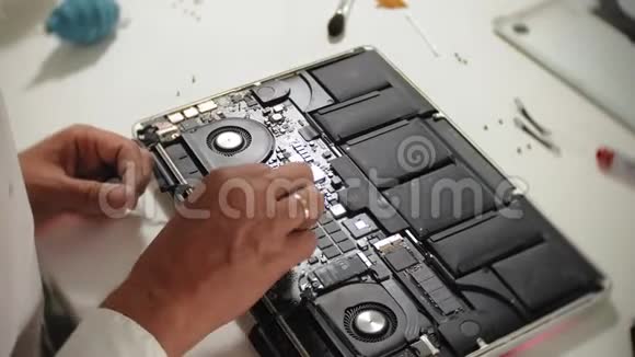 一个人正在修理笔记本电脑计算机修复的概念用一个人修理笔记本电脑主板视频的预览图