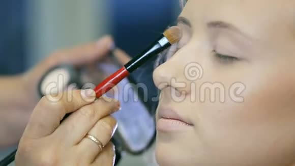 专业化妆师将色调粉末应用于金发模特眼睑视频的预览图