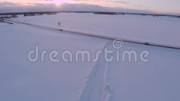 冬天的路空中镜头白雪覆盖的白田日落视频的预览图