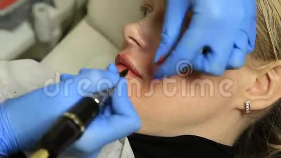 应用永久性化妆的美容师年轻漂亮的女人嘴唇上有化妆品纹身健康水疗中心视频的预览图