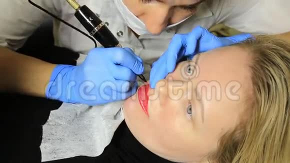 应用永久性化妆的美容师年轻漂亮的女人嘴唇上有化妆品纹身健康水疗中心视频的预览图