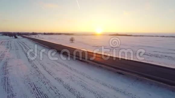 冬天的路空中镜头白雪覆盖的白田日落视频的预览图
