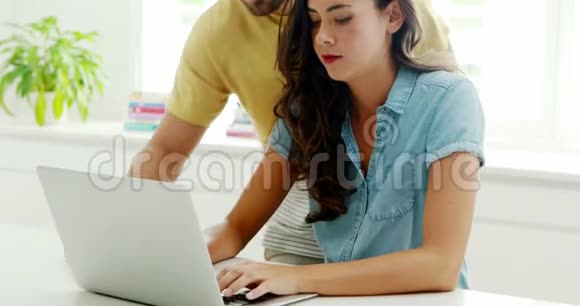 一对夫妇在厨房用笔记本电脑视频的预览图