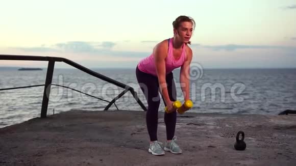 年轻女运动员在海滩上工作视频的预览图