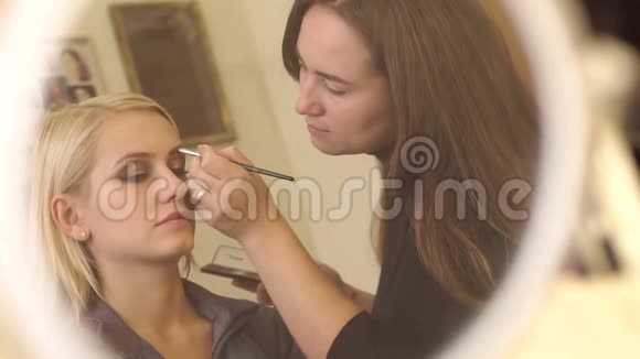 化妆师和模特的镜子里的倒影视频的预览图