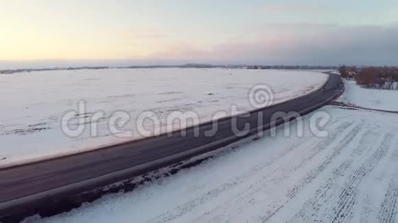 冬天的路空中镜头白雪覆盖的白田日落视频的预览图