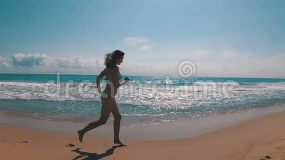 小女孩沿着海岸海滩慢动作奔跑视频的预览图