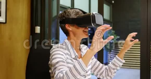 商务女性在办公室4k使用虚拟现实耳机时做手势视频的预览图