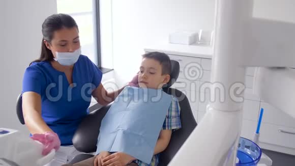 女牙医带着小孩在牙科诊所视频的预览图