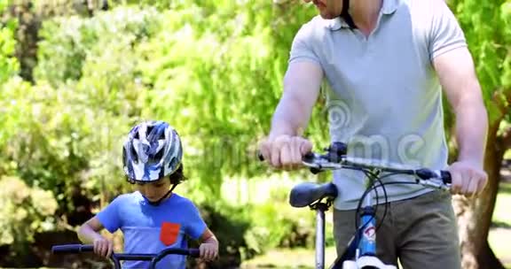 爸爸和小儿子一起在公园骑自行车视频的预览图