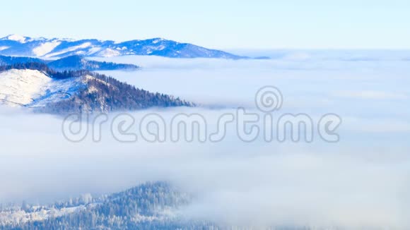 冬季景观冬天雾带着蓝天在山上移动视频的预览图