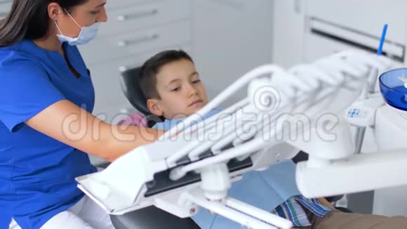 女牙医带着小孩在牙科诊所视频的预览图
