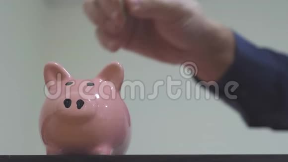 商人储蓄把硬币放在储蓄罐里储蓄罐的商业概念慢动作视频省钱就是视频的预览图