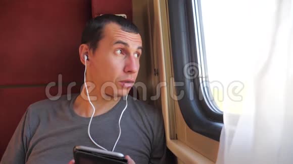 男人听着生活方式的音乐在火车车厢车厢上旅行慢动作视频一个男人视频的预览图