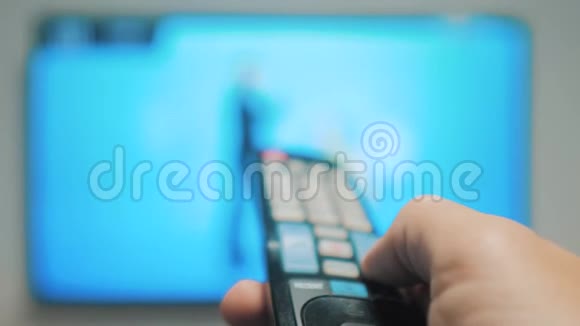 男人的生活方式手握电视遥控器关掉智能电视频道冲浪紧紧抓住男人手里拿着电视视频的预览图