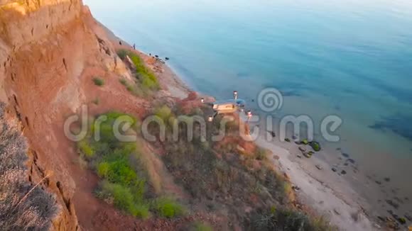日落时分在湖上悬崖上方的空气中钻孔四方直升机特写视频的预览图