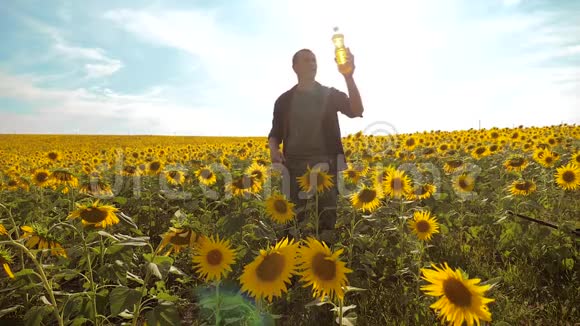 日落时分农夫手捧一瓶葵花籽油农民生活方式农业塑料瓶视频的预览图