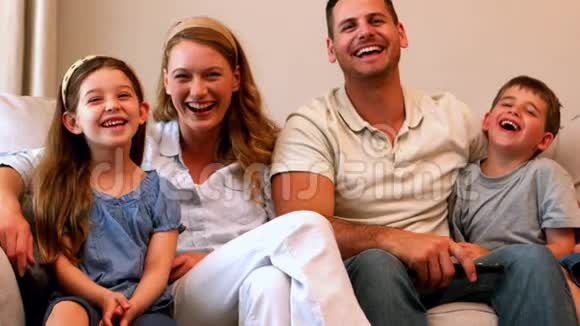 幸福的年轻家庭在沙发上笑视频的预览图