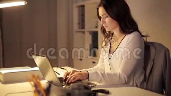 有笔记本电脑的女人在夜间办公室打电话视频的预览图