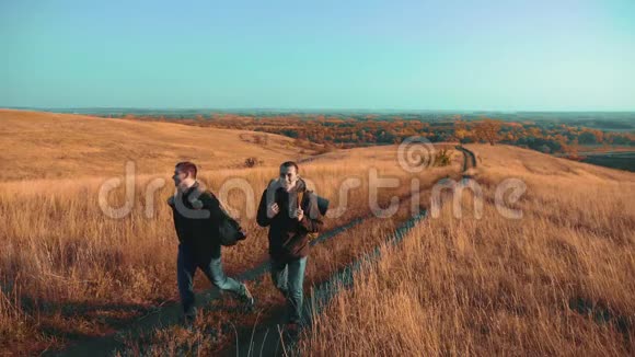 两个带着背包徒步旅行的人正沿着小路走着爬山成了生活方式慢动作视频的预览图