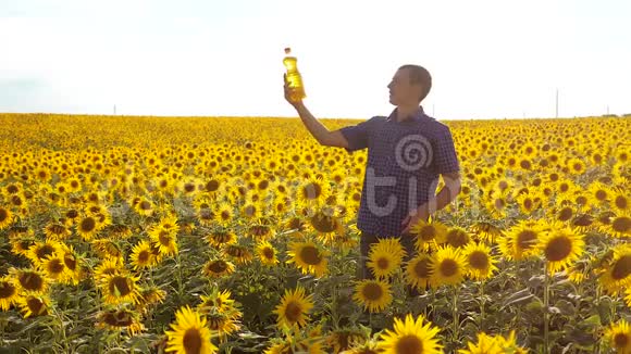 农夫用向日葵在田野里探索慢动作生活方式视频男人的生活方式农民手拿瓶子视频的预览图