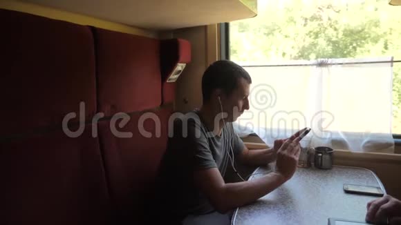 火车上的人火车上的人火车上的人听着耳机里的音乐在信使社交媒体上留言视频的预览图