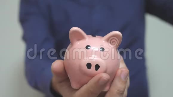 商人把钱放在生活方式的储蓄罐里猪银行的经营理念慢动作录像节约视频的预览图