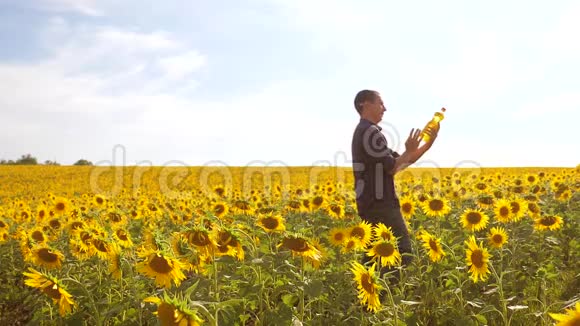 日落时分农夫手捧一瓶葵花籽油慢动作生活方式视频农民农业视频的预览图