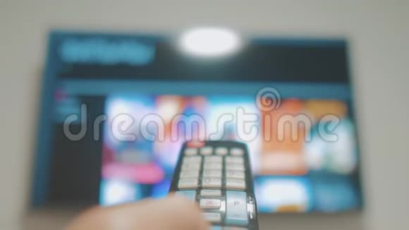 带有应用程序和手持设备的智能电视男性手持遥控器关闭智能电视手动生活方式控制电视视频的预览图