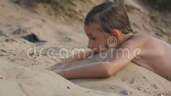 这孩子正在沙滩上慢动作地玩沙视频的预览图