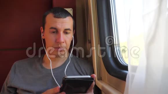 男子在火车上听音乐火车车厢轿跑车旅行慢动作视频生活方式a的男人视频的预览图