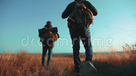 两个人带着背包徒步旅行沿着小路走着生活方式爬上了山慢动作视频的预览图