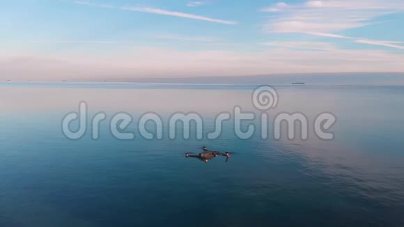 日落时分在湖上悬崖上方的空气中钻孔四方直升机特写视频的预览图