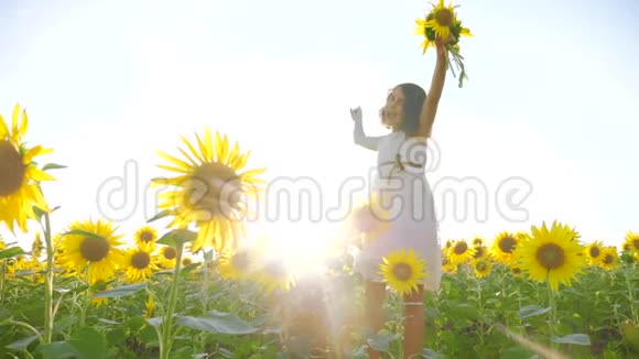 快乐的生活方式小女孩在夏天向日葵的阳光下美丽的日落小女孩向日葵视频的预览图