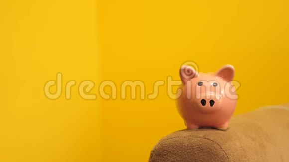 猪银行的经营理念手的生活方式是把硬币放在黄色背景的储蓄罐里省钱就是视频的预览图