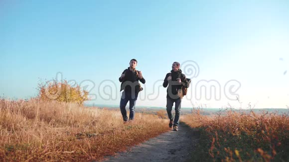 两个背着背包徒步旅行的人正沿着小路爬山慢速视频视频的预览图