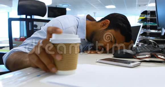男性行政人员在办公桌上睡觉视频的预览图