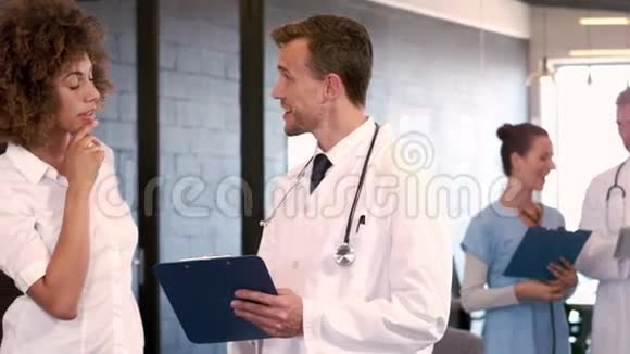 医生一边看剪贴板一边和护士说话视频的预览图