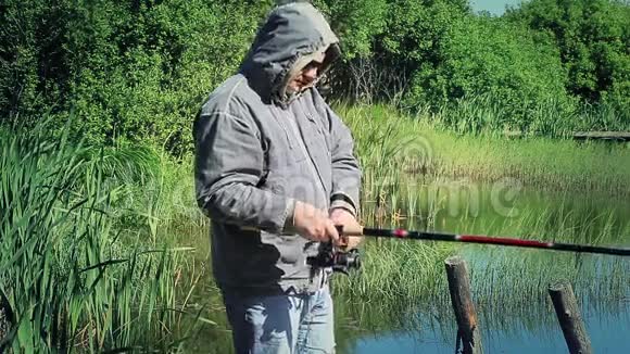 早上在湖边拿着鱼竿的渔夫视频的预览图