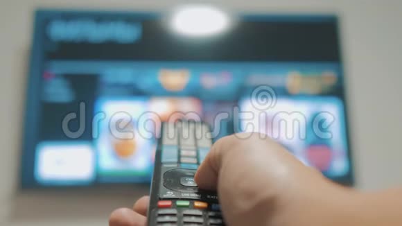 智能电视应用程序和生活方式的手男性手持遥控器关闭智能电视生活方式人手视频的预览图