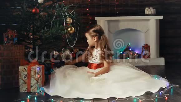 小女孩和圣诞树下的圣诞礼物视频的预览图