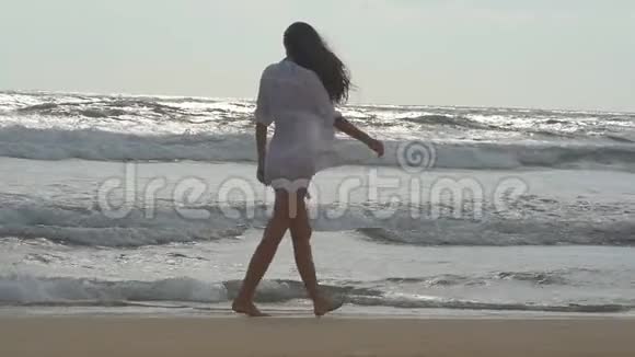 年轻漂亮的女孩在海边享受生活和乐趣快乐的女人在海边散步夏天视频的预览图