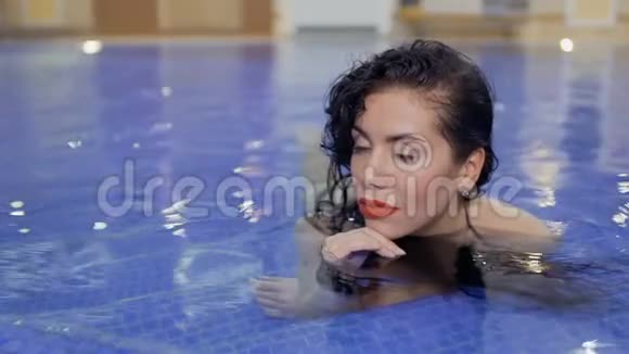 美丽的女人在游泳池里放松视频的预览图
