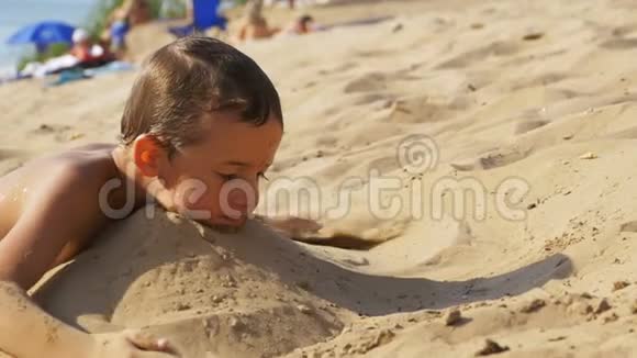 小孩在沙滩上慢动作玩沙视频的预览图