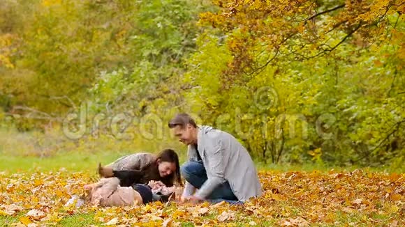 有小孩的年轻家庭在秋天公园玩得开心视频的预览图