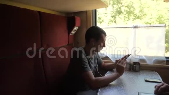 火车车厢上的人的剪影听着耳机上的音乐在信使社交媒体上留言视频的预览图