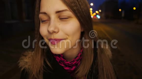 一个可爱的沉思微笑的少女在夜城街的肖像视频的预览图