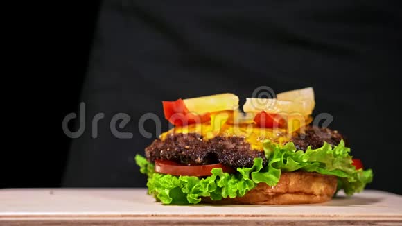 汉堡在黑色背景下用黑色食物手套做饭非常美味的空气面包和大理石牛肉餐厅视频的预览图