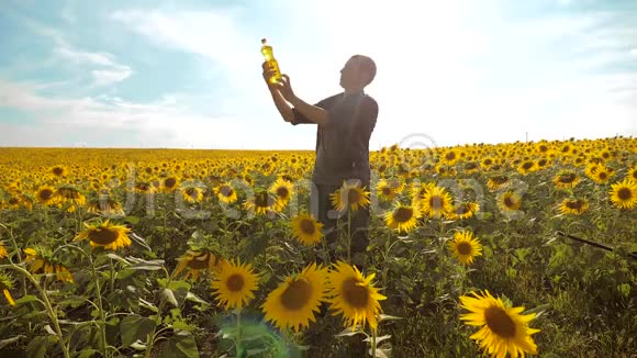 日落时分农夫手拿一瓶向日葵油满族农耕塑料瓶油生活方式视频的预览图