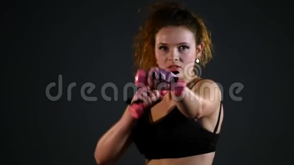 漂亮强壮的女人用哑铃练习视频的预览图